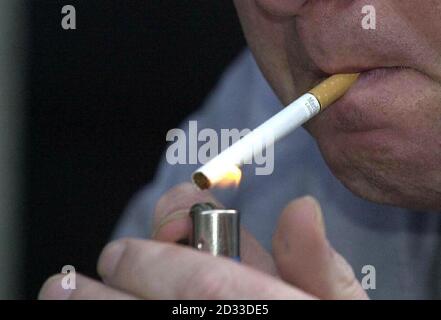 People smoke in a designated smoking area outside Shinjuku Station on ...