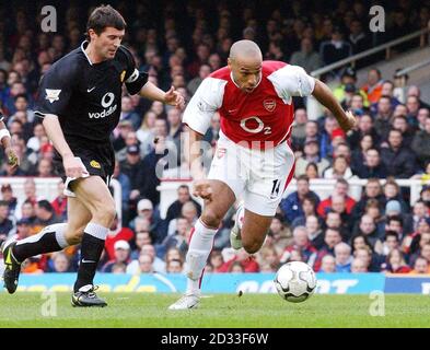 Arsenal's Thierry Henry gets away from Manchester United's Roy Keane (left) during the Premiership match at Highbury, London.  THIS PICTURE CAN ONLY BE USED WITHIN THE CONTEXT OF AN EDITORIAL FEATURE. NO WEBSITE/INTERNET USE UNLESS SITE IS REGISTERED WITH FOOTBALL ASSOCIATION PREMIER LEAGUE. Stock Photo