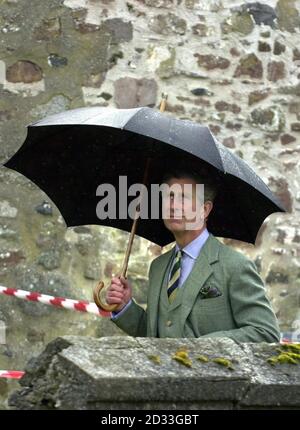 The Prince of Wales the Duke of Rothsey shelters from the April showers during a visit to Fyvie Castle, Aberdeenshire to view the North East of Scotland Skills Training Centre. Stock Photo