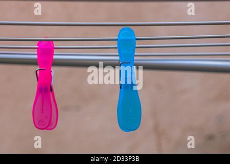 Colorful plastic clothes pegs on empty metal clothes dryer. Stock Photo