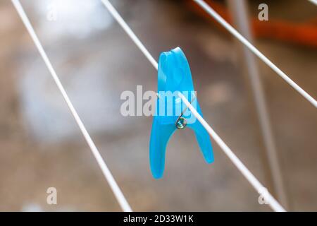 Colorful plastic clothes peg on empty metal clothes dryer. Stock Photo