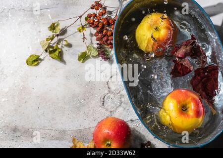 Apples and autumn colorful leaves on a gray background with raindrops. Stock Photo