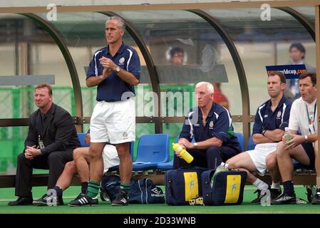 Republic of Ireland manager Mick McCarthy (standing) and his coaching staff, watch on from the bench during the first round, Group E game of the World Cup at Big Swan Stadium, Niigata. Stock Photo