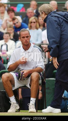 EDITORIAL USE ONLY, NO COMMERCIAL USE. Xavier Malisse of Belgium speaks with trainer Bill Norris after experiencing chest pains during his semi-final match against the Argentinian David Nalbandian on Court One at Wimbledon. Malisse contravertialy left the court for ten minutes to receive medical attention after losing the first set tie break. Stock Photo