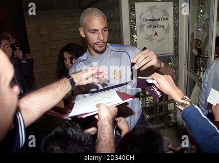 Manchester United's Rio Ferdinand signs autographs for waiting fans as the Manchester United team arrive for a training session at G.S.P. Stadium, Nicosia, Cypruahead of the Champions League match against Maccabi Haifa. 15/05/04: Football star Rio Ferdinand has praised a scheme to encourage young players from different communities, it emerged today. The Manchester United and England star, who is currently serving an eight-month ban, met youngsters at a football project in Ashton-under-Lyne, Greater Manchester. See PA Story SOCIAL Ferdinand. PA Photo: David Davies. Stock Photo