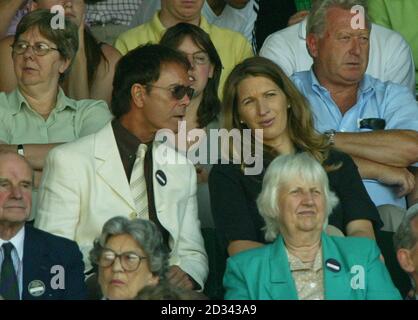 EDITORIAL USE ONLY, NO MOBILE PHONE USE. Sir Cliff Richard and former Wimbledon champion Steffi Graff watch Steffi's husband Andre Agassi in action on Centre Court against Britain's Jamie Delgado at the All England Lawn Tennis Championships in Wimbledon.