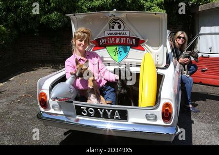 EDITORIAL USE ONLY Artist Sophie Newell (left) and fair curator Karen Ashton, with Maggie an English Bull Terrier, Purdy a Lurcher and Lottie a Whippet, pose with a vintage Vauxhall Viva, at a studio in Camberwell, south London, ahead of the Vauxhall Art Car Boot Fair, which will be taking place at Brick Lane Yard on Sunday 14 June 2015. Stock Photo