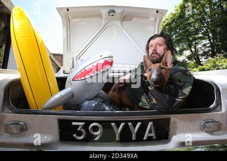 EDITORIAL USE ONLY Artist Marcus Harvey and Maggie an English Bull Terrier, sit in the boot of a vintage Vauxhall Viva, at a studio in Camberwell, south London, ahead of the Vauxhall Art Car Boot Fair, which will be taking place at Brick Lane Yard on Sunday 14 June 2015. Stock Photo
