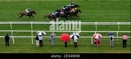 Fayr Jag ridden by jockey David Allan (right wearing yellow & red) surges ahead to win the Stan James Hackwood Stakes at Newbury Racecourse. Stock Photo