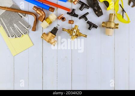 Necessary set tools for plumbers were prepared by craftsman before repair plumbing materials including copper pipe, elbow joint, wrench spanner stainless steel on old wood white background Stock Photo