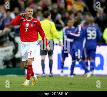 England's David Beckham stands dejected as France players celebrate the opening goal of the match Stock Photo