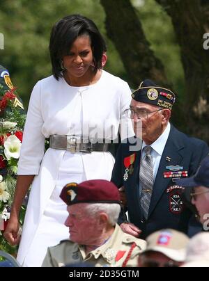 United States of America's First Lady Michelle Obama is escorted by a D-Day veteran as she arrives for a memorial service at the American Cemetery in Colleville-sur-Mer, Normandy, France, on the 65th anniversary of the D-Day landings. Stock Photo