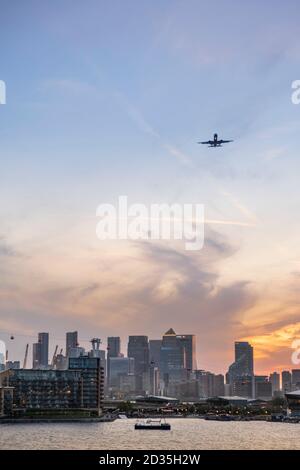 UK, London, Docklands. Aircraft arriving at City Airport, skyline of London's Canary Wharf Central business district, Royal Victoria Dock, East End Stock Photo