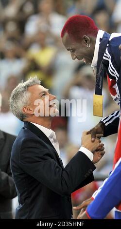 Great Britain's Phillips Idowu is presented with his Gold Medal by former Olympic and World Triple Jump Champion Jonathan Edwards during the IAAF World Championships at the Olympiastadion, Berlin. Stock Photo