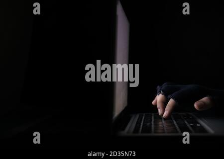 hacker hand stealing data from laptop isolated on black  Stock Photo