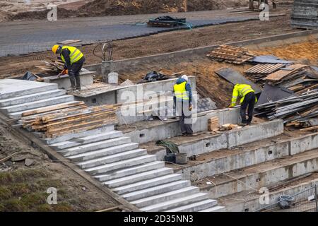 Builders working on construction foundation. Man strengthen concrete structure on the hill slope Stock Photo