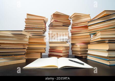 Big stack of books on the table. Studying before the exam. Pile of vintage books. Concept of education and studying Stock Photo