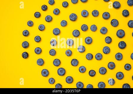 Blueberry pattern on yellow background. Ripe blueberries texture close up. Stock Photo