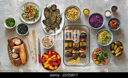 Various vegetarian dishes and salads on a light dining table Stock Photo