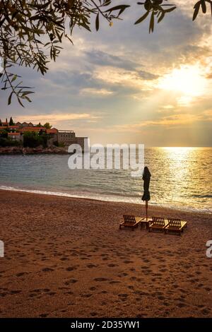 Sveti Stefan historical town island and paradise sand beach at sunset. Budva riviera, Montenegro (Adriatic Sea), Europe. Travel concept, background. Stock Photo