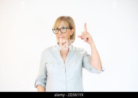 Senior woman wearing casual blouse over isolated background cheerful with a smile of face pointing with hand and finger up to the side with happy and Stock Photo