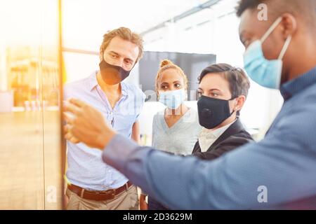 Business people at business meeting with face mask in the office because of coronavirus and Covid-19 Stock Photo