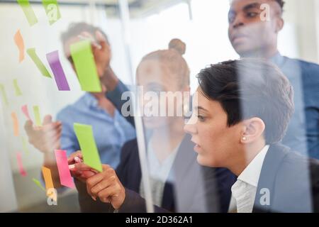 Business people as a creative team with sticky notes in a brainstorming seminar Stock Photo