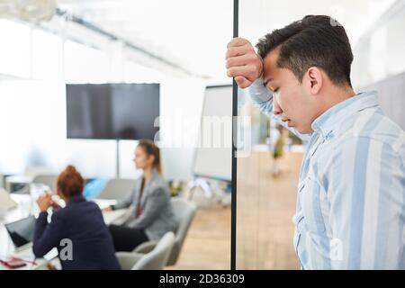 Asian business man stands tired and exhausted in the office because of overtime Stock Photo