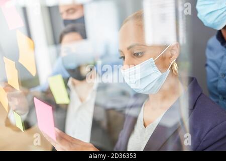 Business people in brainstorming workshop with mask because of Covid-19 Stock Photo