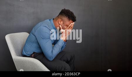 African business man with hands in front of face for despair Stock Photo