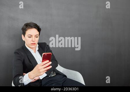 Young businesswoman reading a text message as a message or warning on the smartphone Stock Photo