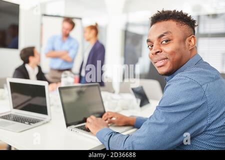 African programmer or creative developer working on laptop computer Stock Photo