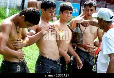 Wrestlers have their bodies covered in olive oil prior to competition starting at the Kirkpinar Turkish Oil Wrestling Festival at Edirne in Turkey. Stock Photo