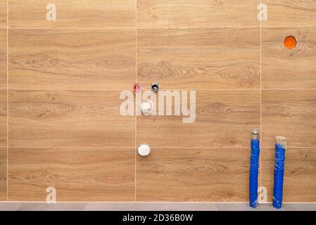 Pipes with water coming out of the floor and from the wall and sewer pipes in the wall in a modern boiler room lined with brown ceramic tiles. Stock Photo