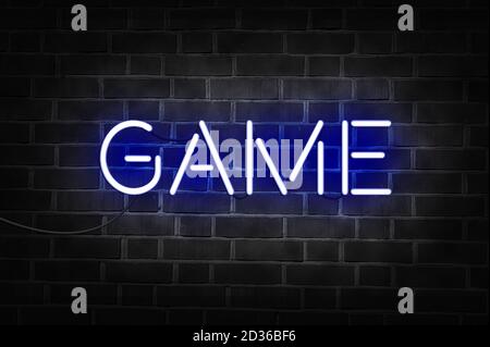 Blue neon sign of the word GAME on dark brick wall. Stock Photo