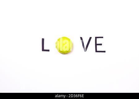 Love creative background. Hand lettering word love and sweet macaroon on white background.  Sweet love concept. Stock Photo