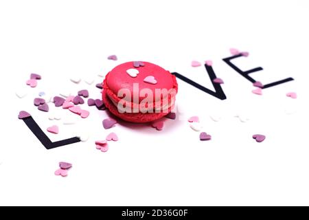 Love. Pink macaroon and hand drawn letters with little hearts. Sweet love concept. Stock Photo