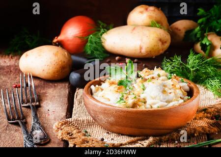 Traditional Russian vareniki with potatoes and fried onions in bowl on old wooden table, rustic style, selective focus Stock Photo