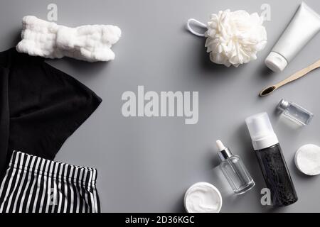 black and white pajamas and a set of cosmetics for an evening beauty routine. Stock Photo