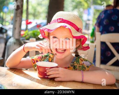 Smiling happy young girl of six eating ice cream on a hot summer day, Sofia, Bulgaria Stock Photo