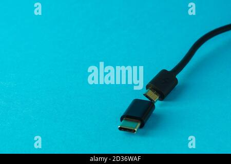 Micro USB to Type C small adapter and cable on blue background, selective focus, copy space Stock Photo