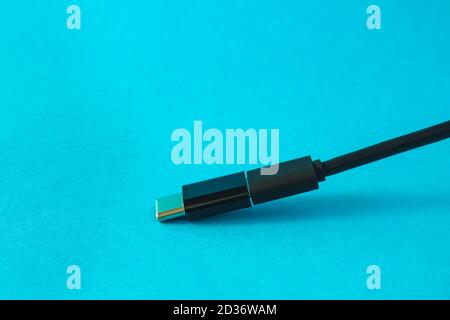Micro USB cable with small adapter to Type C on blue background, selective focus, copy space Stock Photo