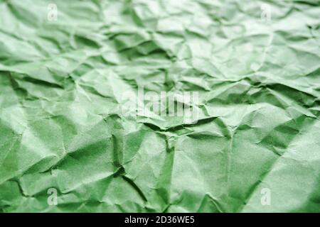 Crumpled green paper, abstract background, selective focus Stock Photo