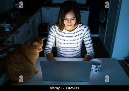 Concentrated woman working late hours with her laptop Stock Photo
