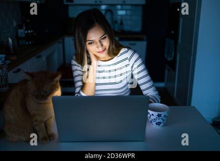 Concentrated woman working late hours with her laptop Stock Photo