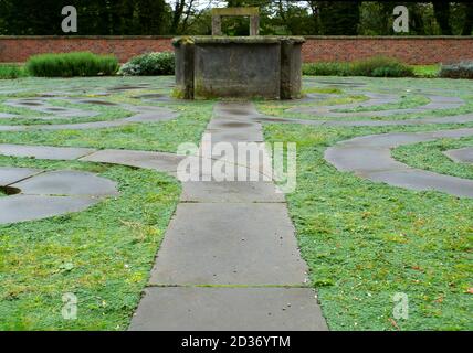 The reconstructed labyrinth of stones and moss .In the middle of the old well, which is not supposed to collect water, but light. A metaphor. Stock Photo