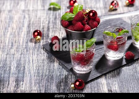Alcohol shots of berries cocktail with a raspberry
