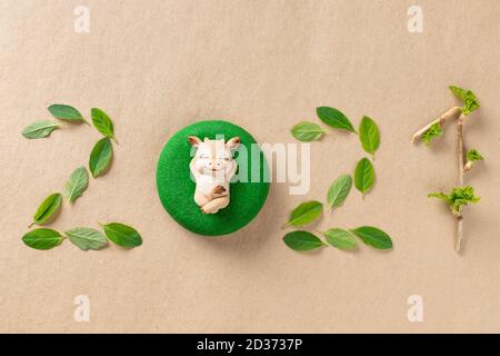 numbers 2021 made from green leaves and christmas bull symbol on craft paper Stock Photo