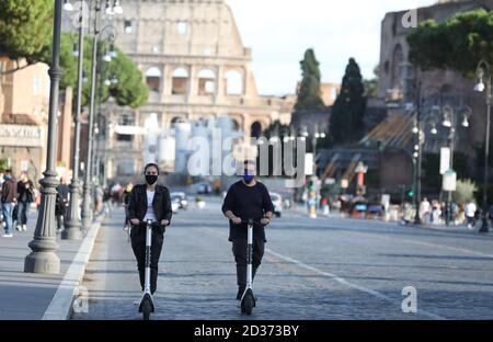 Rome, Italy. 6th Oct, 2020. People wearing face masks ride electric scooters in Rome, Italy, Oct. 6, 2020. Five southern regions of Italy have introduced mandatory mask laws, even for people in open spaces. And the government has announced that the national state of emergency, first put into place on Jan. 31, would be extended 'at least' until its one-year anniversary. Credit: Cheng Tingting/Xinhua/Alamy Live News Stock Photo