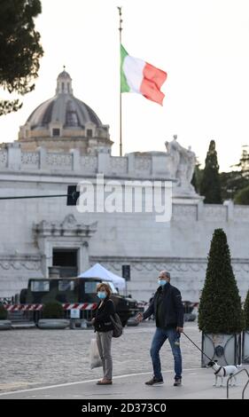 Rome, Italy. 6th Oct, 2020. People wearing face masks walk at Piazza Venezia in Rome, Italy, Oct. 6, 2020. Five southern regions of Italy have introduced mandatory mask laws, even for people in open spaces. And the government has announced that the national state of emergency, first put into place on Jan. 31, would be extended 'at least' until its one-year anniversary. Credit: Cheng Tingting/Xinhua/Alamy Live News Stock Photo